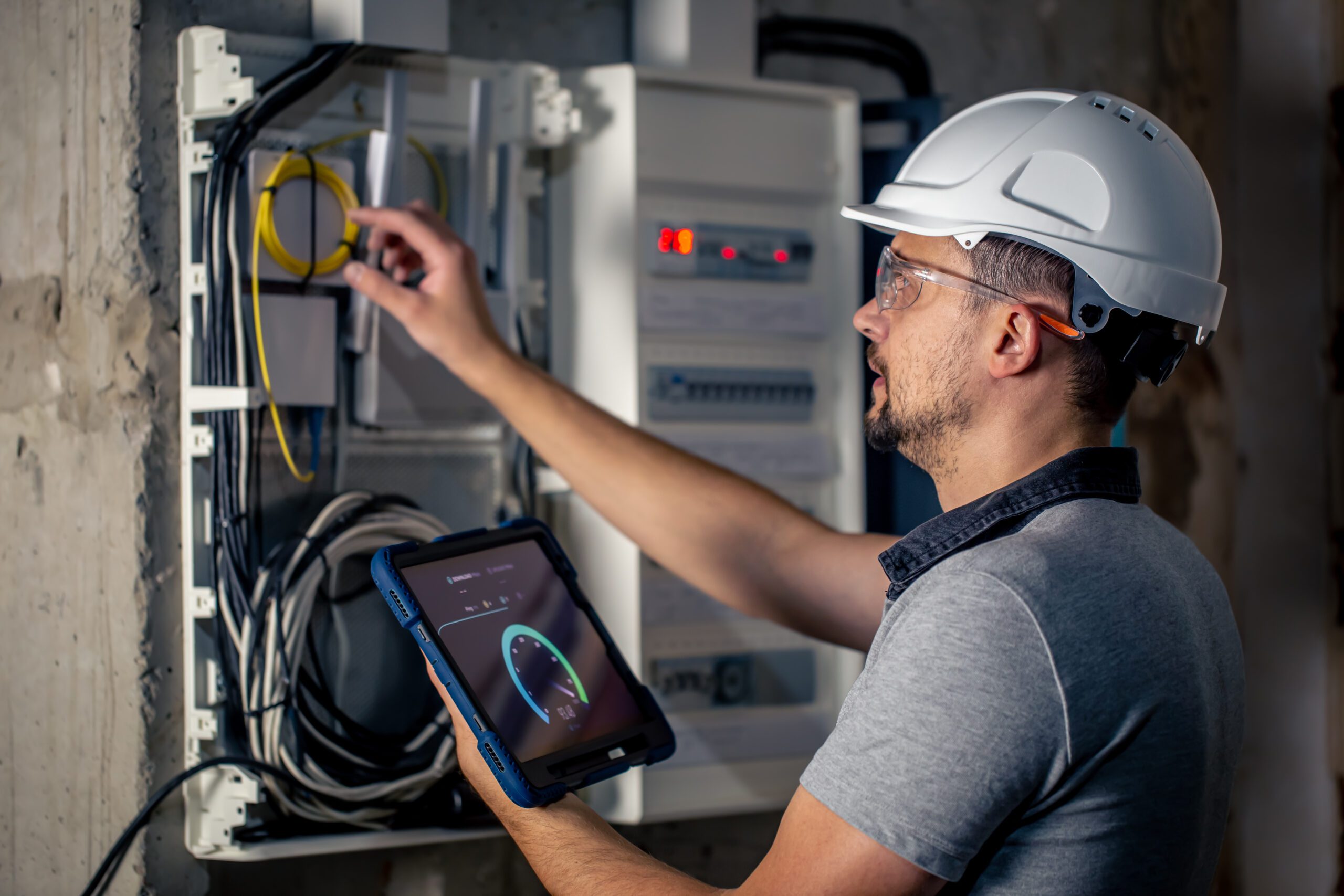 Man, an electrical technician working in a switchboard with fuses. Installation and connection of electrical equipment.